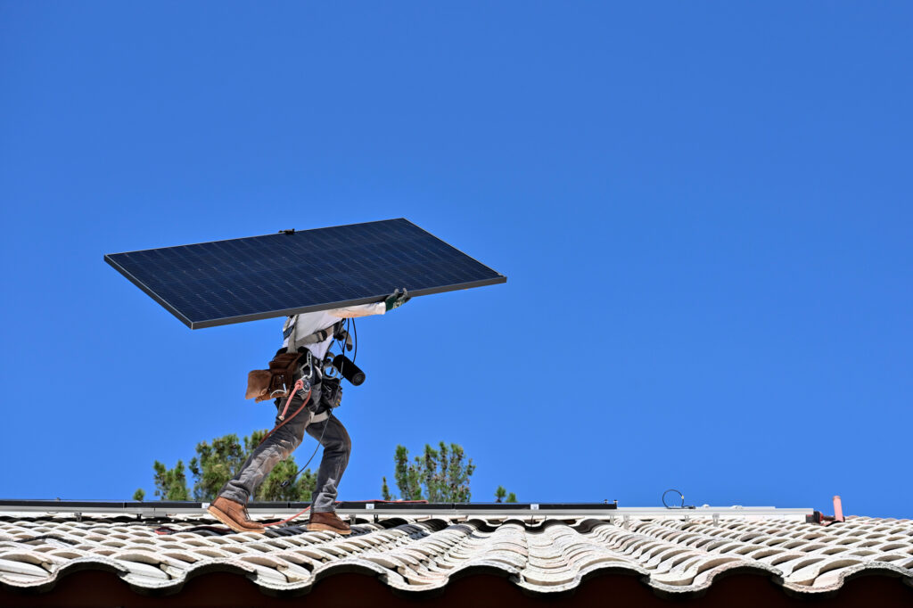A worker carries a solar panel for installation on the roof of a home in Las Vegas. Credit: David Becker/The Washington Post via Getty Images