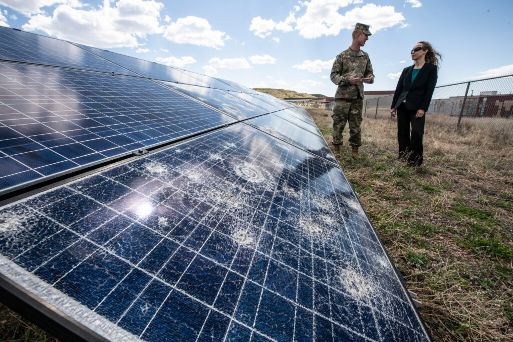 A researcher from the National Renewable Energy Laboratory reviews hail damage at a solar array at Fort Carson in Colorado in 2019. Credit: Dennis Schroeder/NREL