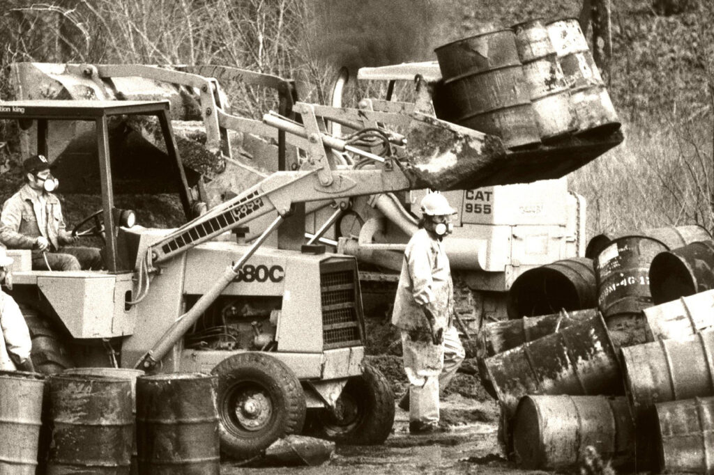 Workers move chemical drums in 1979 to protect a small stream from contamination at the "Valley of the Drums" in Bullitt County, Kentucky. Credit: The Courier-Journal File Photo