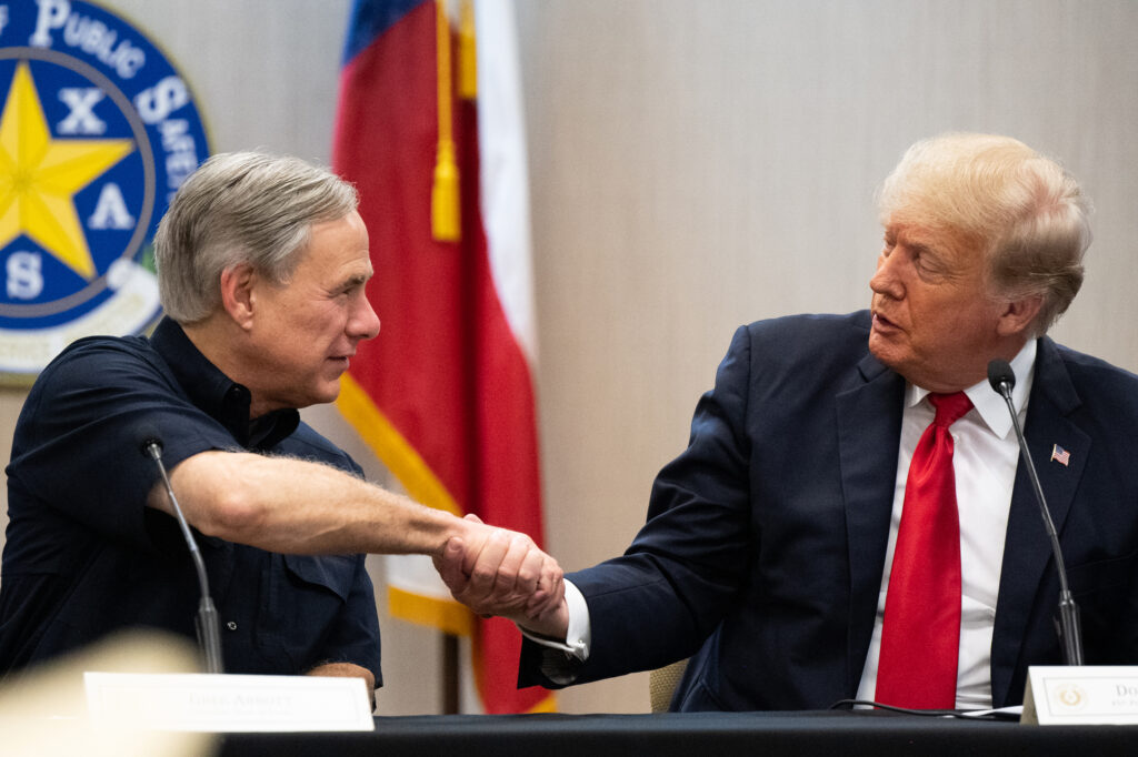 Texas Gov. Greg Abbott and former President Donald Trump shake hands during a briefing on June 30, 2021 in Weslaco, Texas. Credit: Brandon Bell/Getty Images